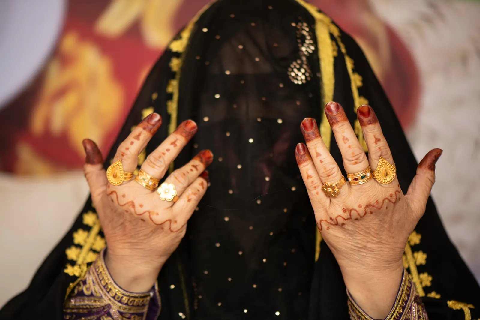 Hands adorned with henna and gold rings