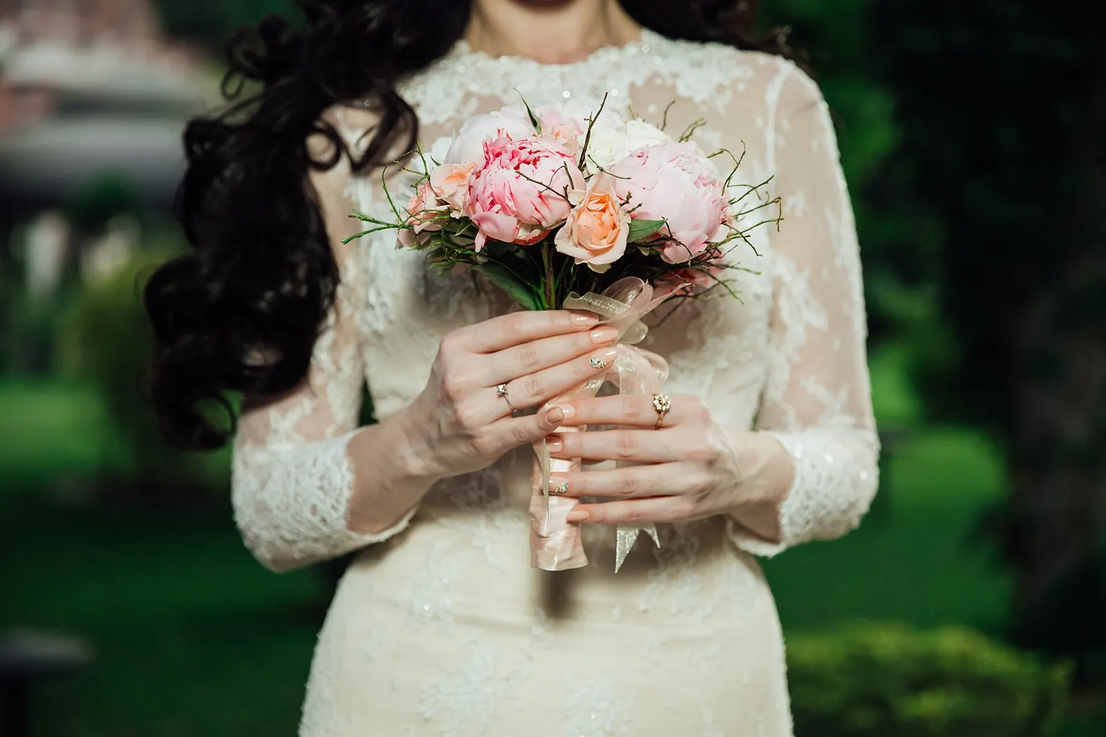 Bride in a lace dress holding her bouquet